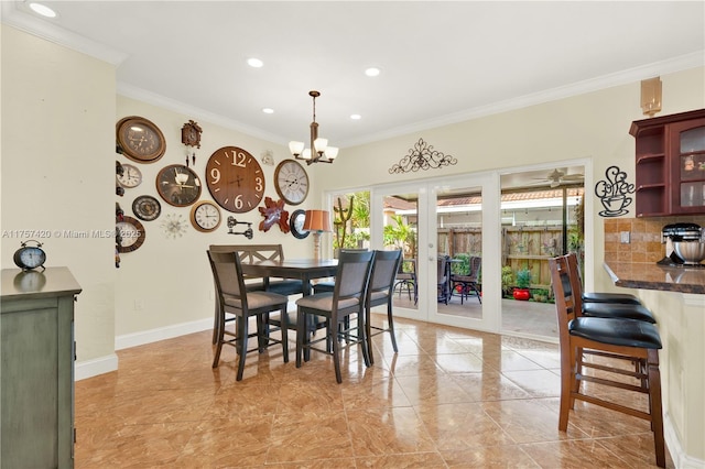 dining room with ornamental molding, french doors, baseboards, and an inviting chandelier