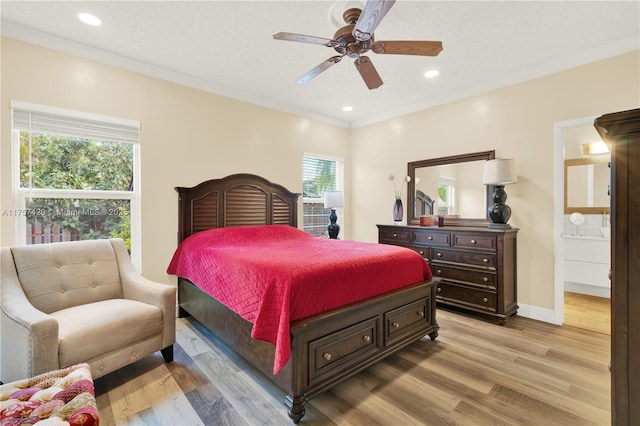 bedroom with a textured ceiling, ornamental molding, recessed lighting, and light wood-style floors