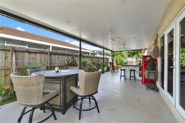 view of patio featuring ceiling fan, outdoor dining space, and fence