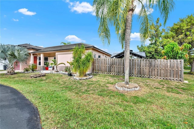 view of yard featuring an attached garage and fence