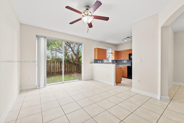 kitchen featuring black appliances, ceiling fan, baseboards, and brown cabinetry