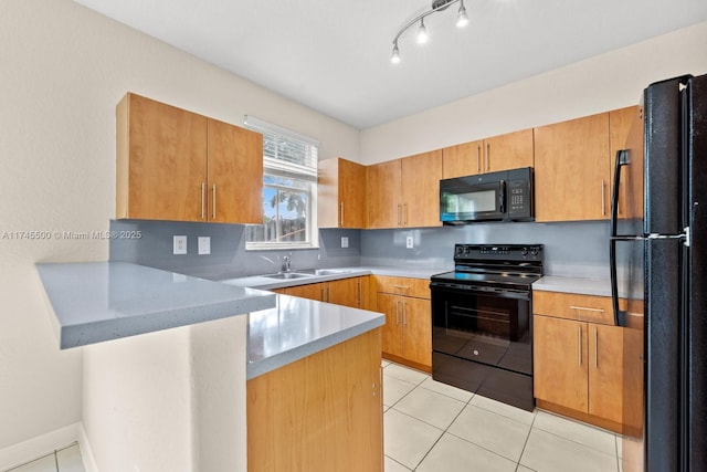 kitchen with a peninsula, light countertops, black appliances, a sink, and light tile patterned flooring