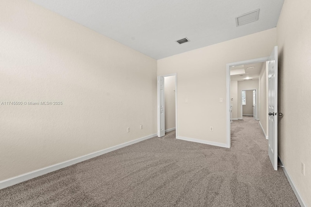 unfurnished bedroom featuring light colored carpet, visible vents, and baseboards