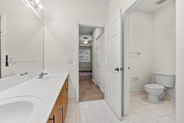 full bathroom featuring double vanity, a sink, toilet, and tile patterned floors