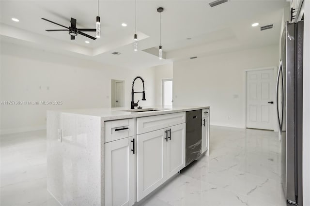 kitchen with marble finish floor, recessed lighting, a raised ceiling, freestanding refrigerator, and a sink