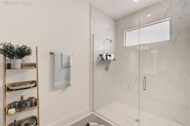 bathroom featuring baseboards and a marble finish shower