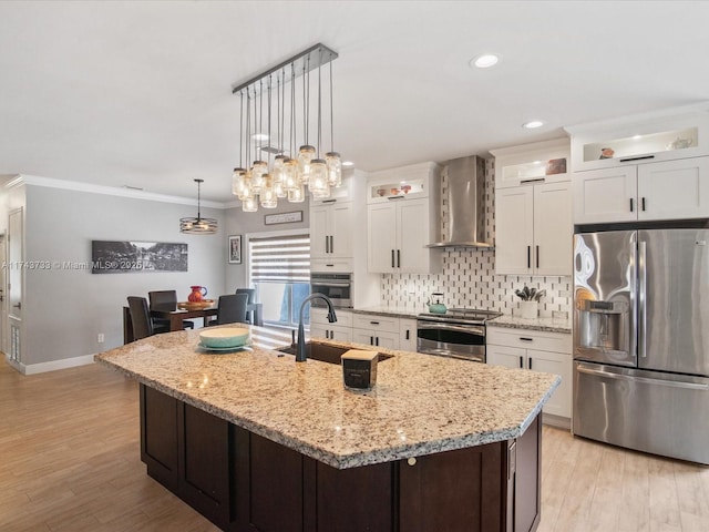 kitchen with a sink, appliances with stainless steel finishes, backsplash, wall chimney exhaust hood, and crown molding