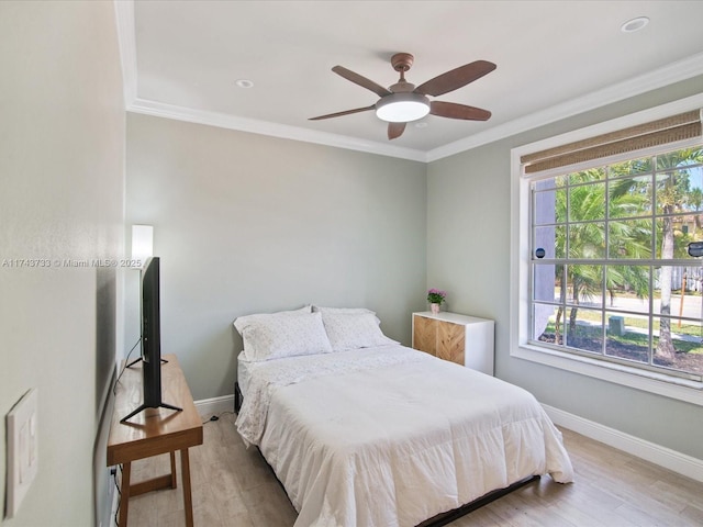 bedroom with ornamental molding, light wood-style floors, and baseboards