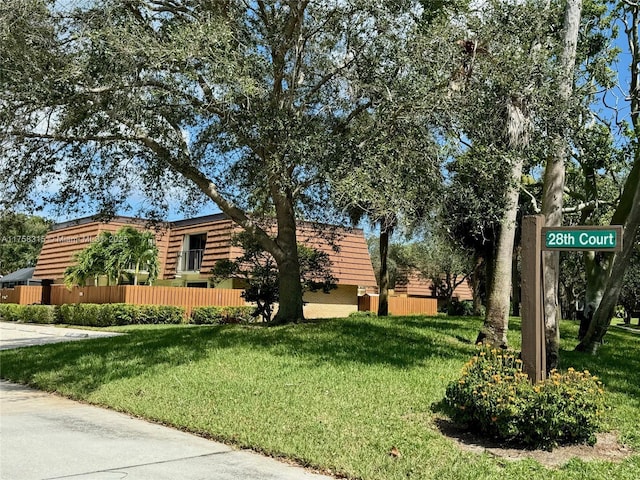 view of property exterior featuring a lawn and fence