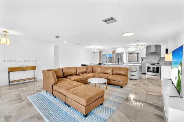 living room featuring visible vents and a notable chandelier