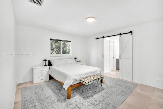 bedroom featuring visible vents, baseboards, and a barn door