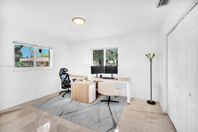 office space with marble finish floor, visible vents, and plenty of natural light