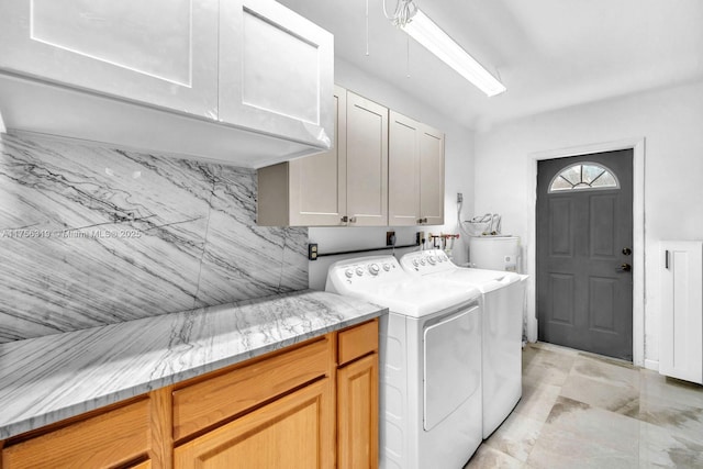 laundry area featuring water heater, cabinet space, and separate washer and dryer