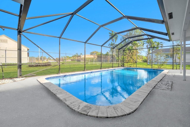 outdoor pool with glass enclosure, a patio area, and a yard