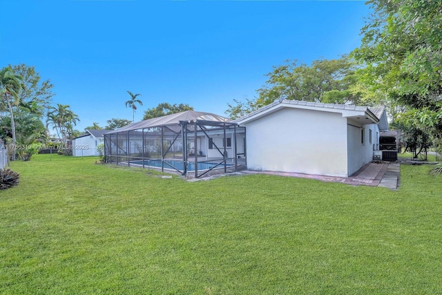 back of property with an outdoor pool, a lawn, a lanai, cooling unit, and stucco siding