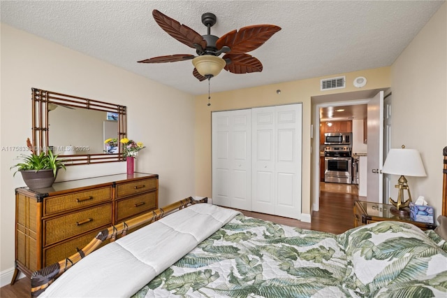 bedroom featuring a textured ceiling, visible vents, a closet, and wood finished floors