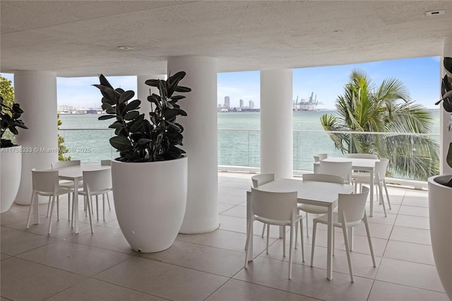 interior space featuring a view of city, a textured ceiling, tile patterned flooring, and floor to ceiling windows