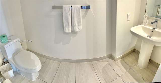 bathroom with toilet and baseboards