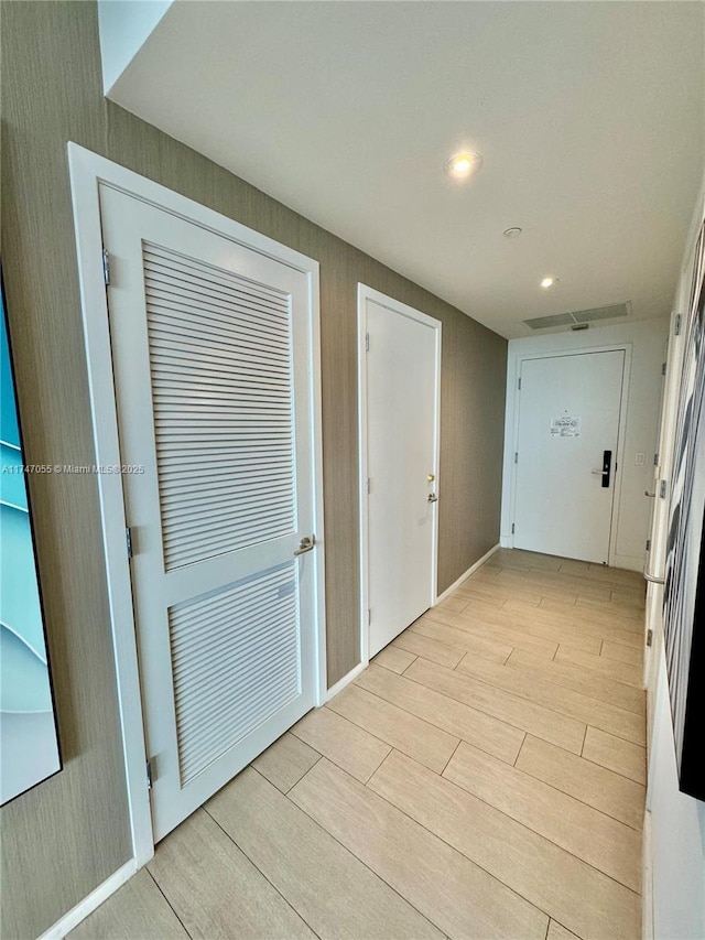 hall featuring light wood-style flooring and recessed lighting