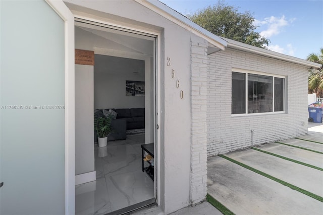 property entrance featuring brick siding