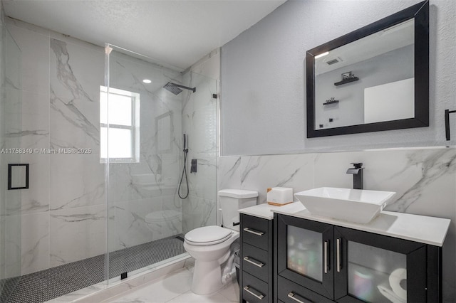 bathroom with toilet, marble finish floor, a marble finish shower, and vanity