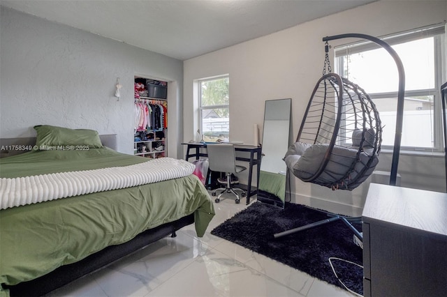 bedroom with a closet, a textured wall, and marble finish floor