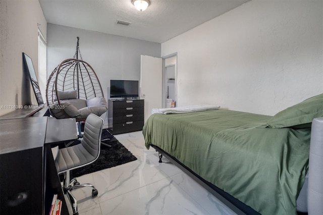 bedroom with marble finish floor, visible vents, a textured ceiling, and a textured wall