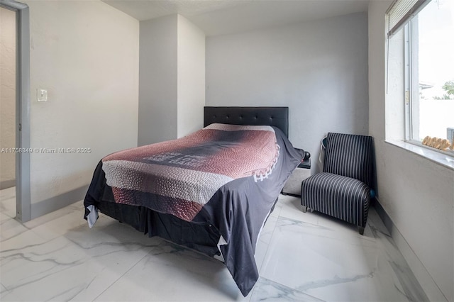 bedroom featuring marble finish floor and baseboards