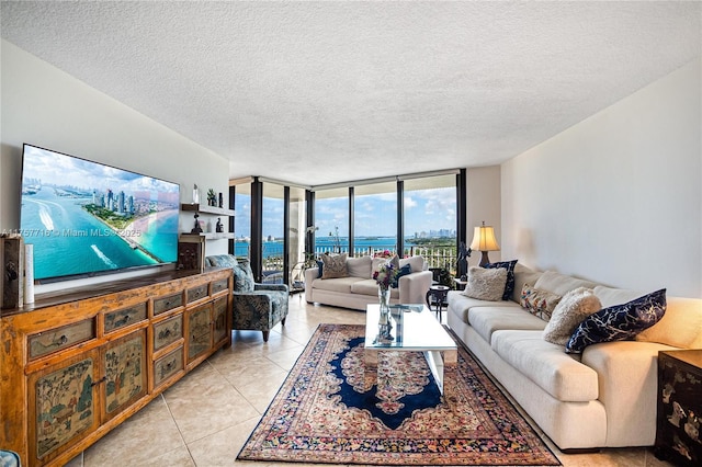 living area featuring a wall of windows, light tile patterned flooring, and a textured ceiling