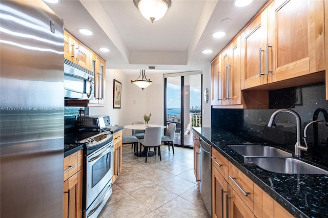 kitchen featuring light tile patterned flooring, a sink, appliances with stainless steel finishes, backsplash, and a raised ceiling