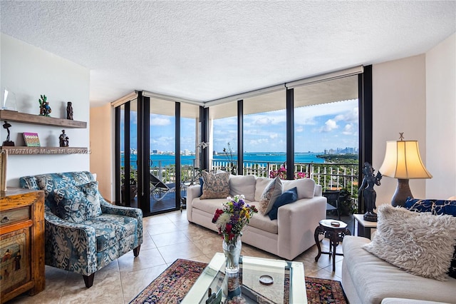 living area with a wall of windows, a healthy amount of sunlight, a water view, and light tile patterned floors