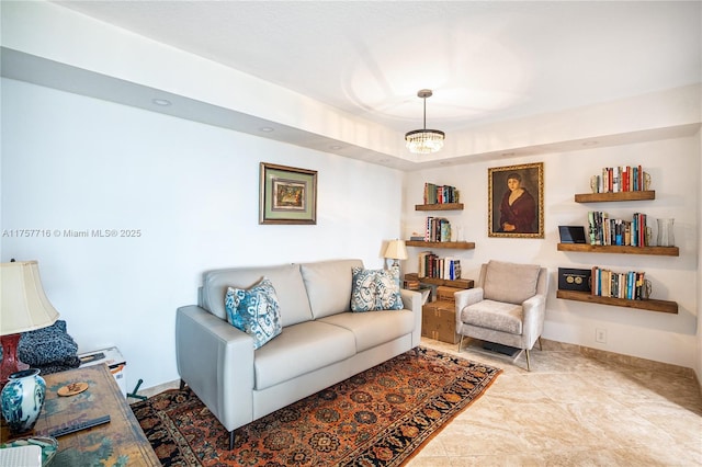 living room with a notable chandelier and baseboards