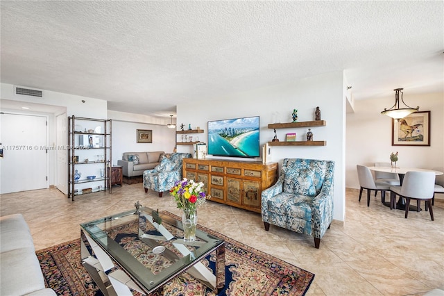 living area with visible vents and a textured ceiling