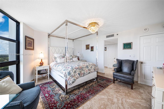 bedroom with baseboards, visible vents, and a wall of windows