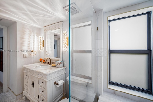 bathroom featuring toilet, vanity, and visible vents