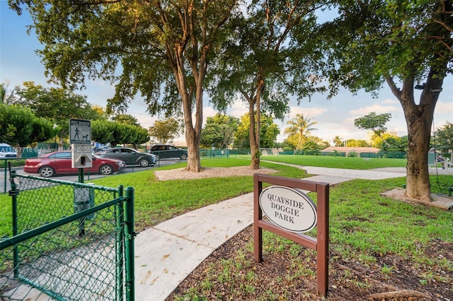 view of property's community with a gate, a lawn, and fence