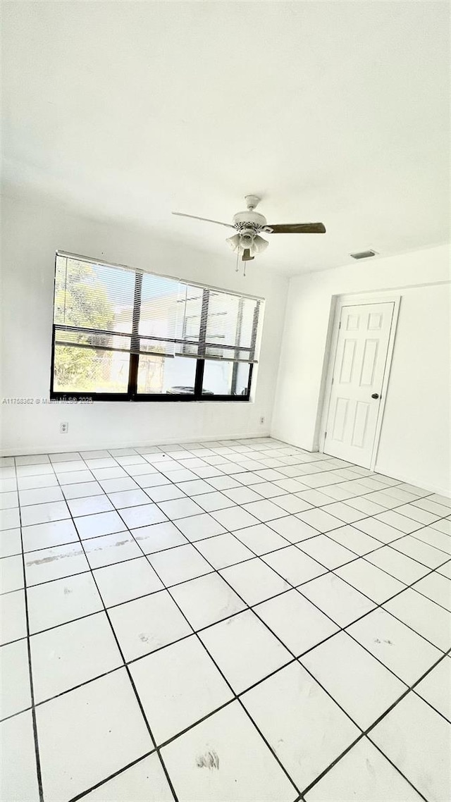 unfurnished room featuring light tile patterned floors, ceiling fan, and visible vents