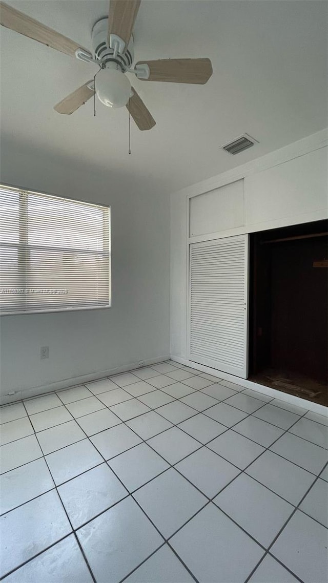 unfurnished bedroom featuring visible vents, ceiling fan, and light tile patterned floors