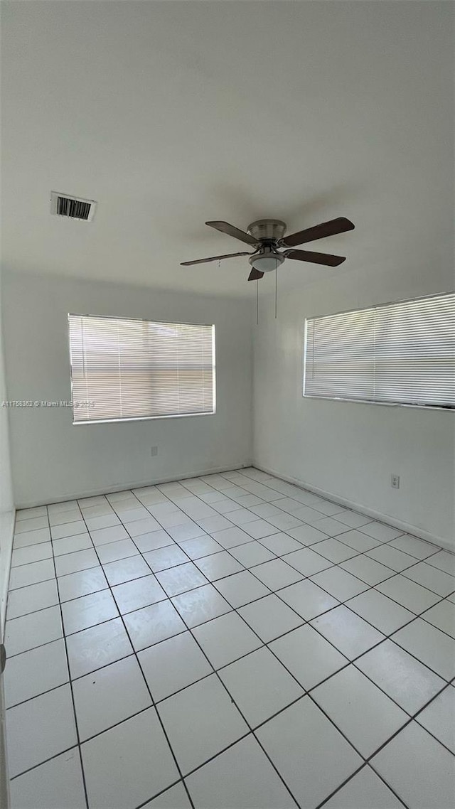 unfurnished room featuring light tile patterned floors, ceiling fan, and visible vents