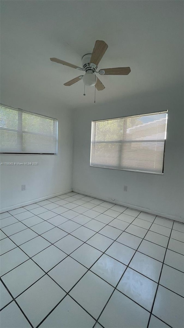 unfurnished room featuring light tile patterned floors and a ceiling fan