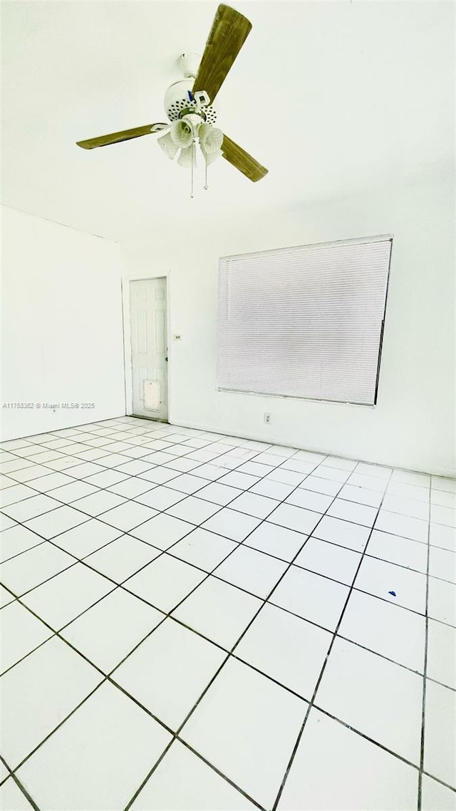 tiled empty room with a ceiling fan