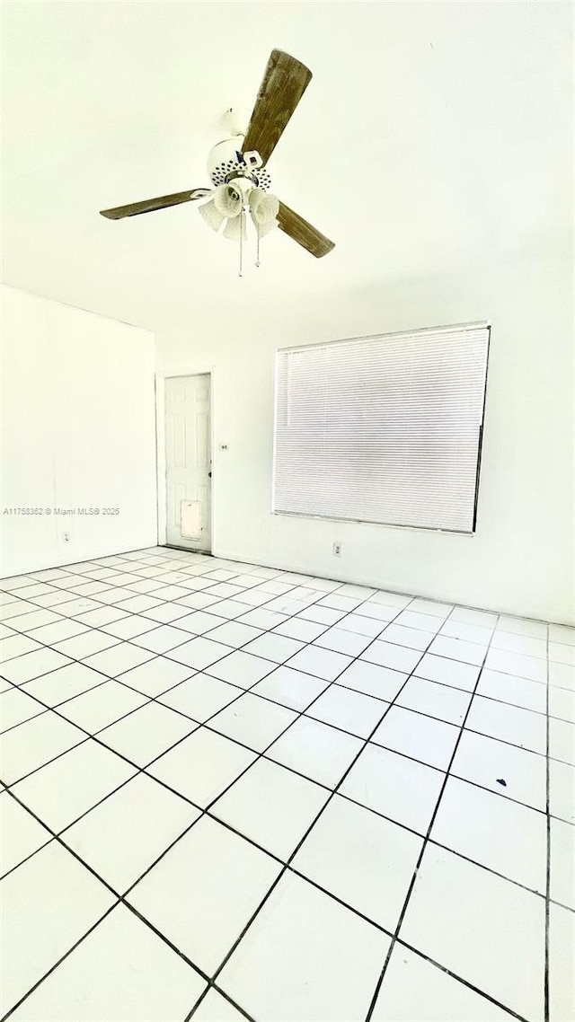 unfurnished room with light tile patterned floors and a ceiling fan