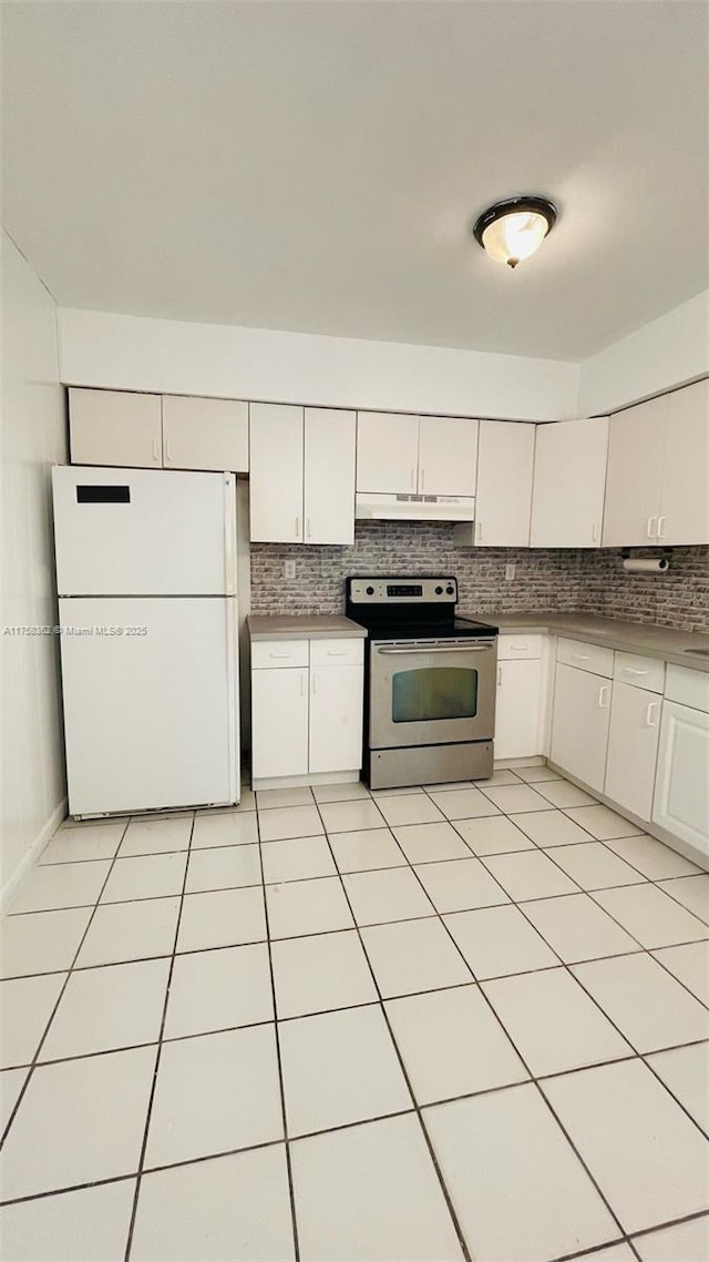 kitchen with stainless steel range with electric stovetop, under cabinet range hood, decorative backsplash, and freestanding refrigerator