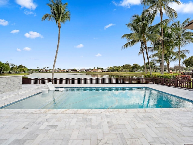 view of swimming pool featuring a fenced in pool, a water view, a patio area, and fence