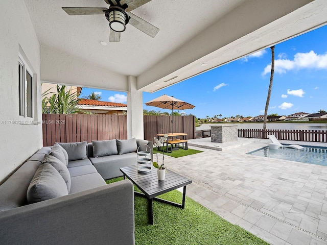 view of patio / terrace featuring a fenced backyard, a water view, ceiling fan, and outdoor lounge area