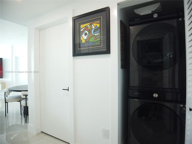 laundry room featuring stacked washer and dryer, laundry area, and light tile patterned floors