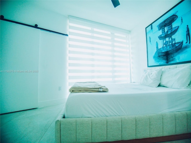 bedroom featuring ceiling fan and a barn door
