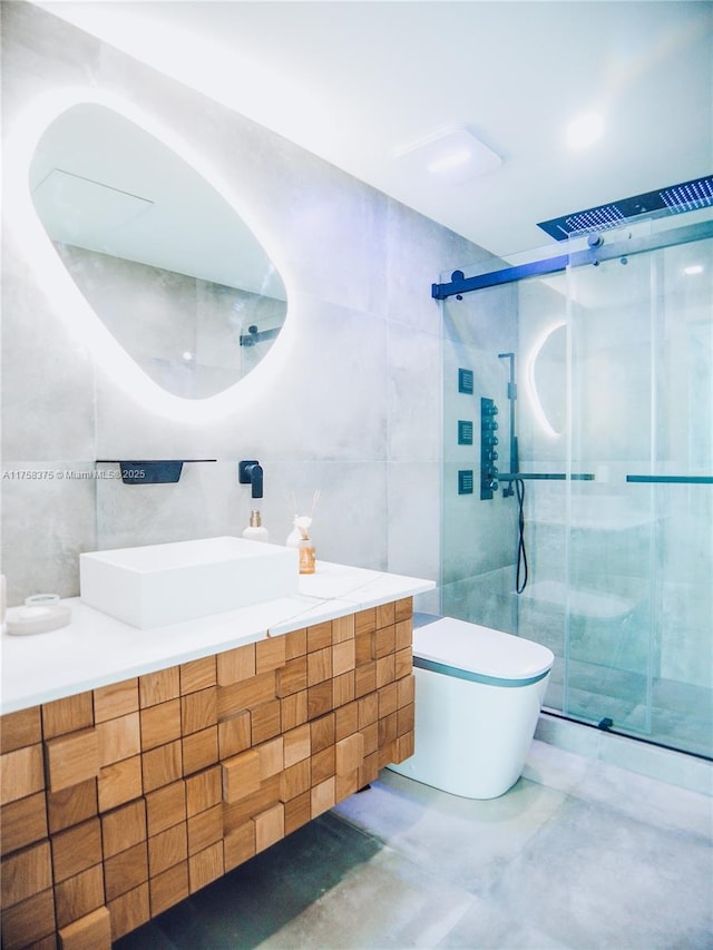 full bath with a shower stall, tile walls, toilet, and vanity