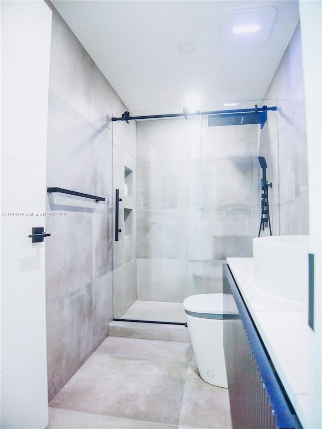 bathroom with toilet, a stall shower, vanity, and tile walls