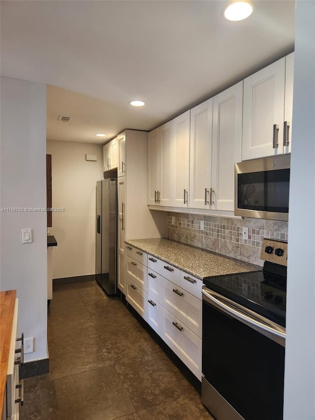 kitchen featuring visible vents, stainless steel appliances, tasteful backsplash, and white cabinetry